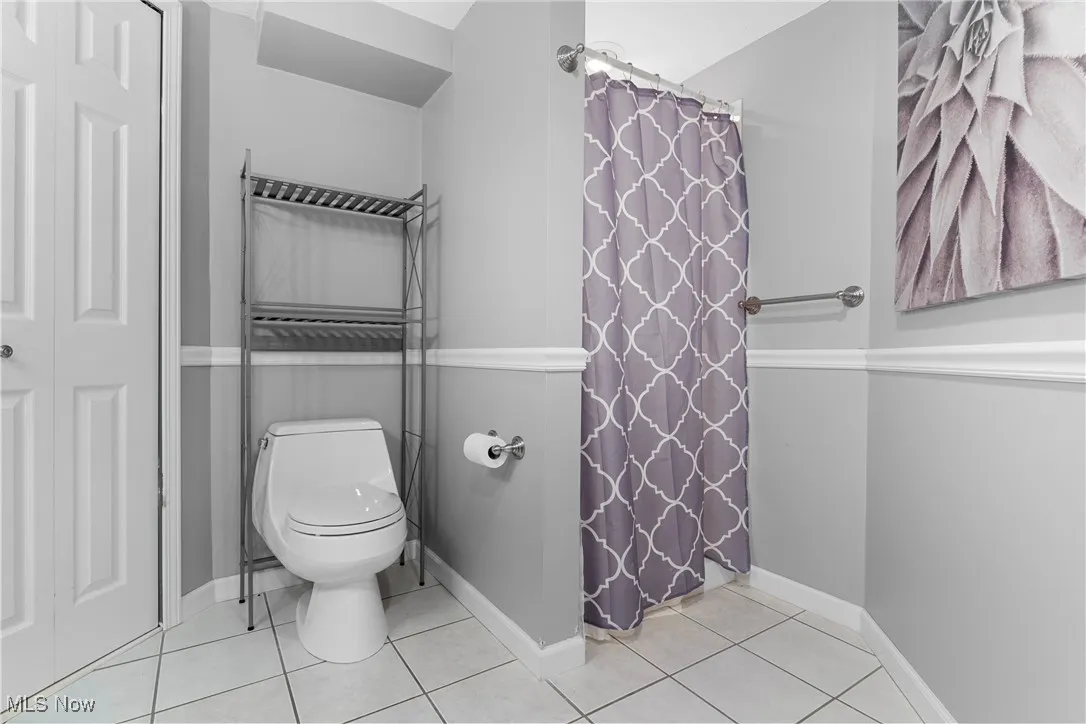 Bathroom featuring tile patterned flooring and curtained shower