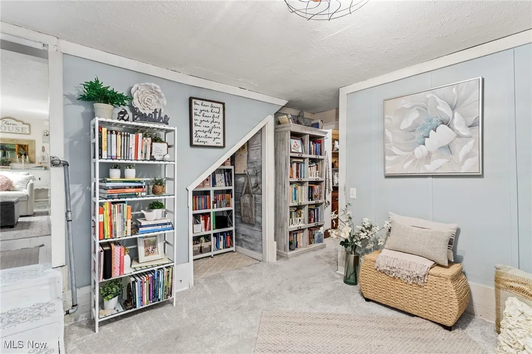 Sitting room with a textured ceiling and carpet