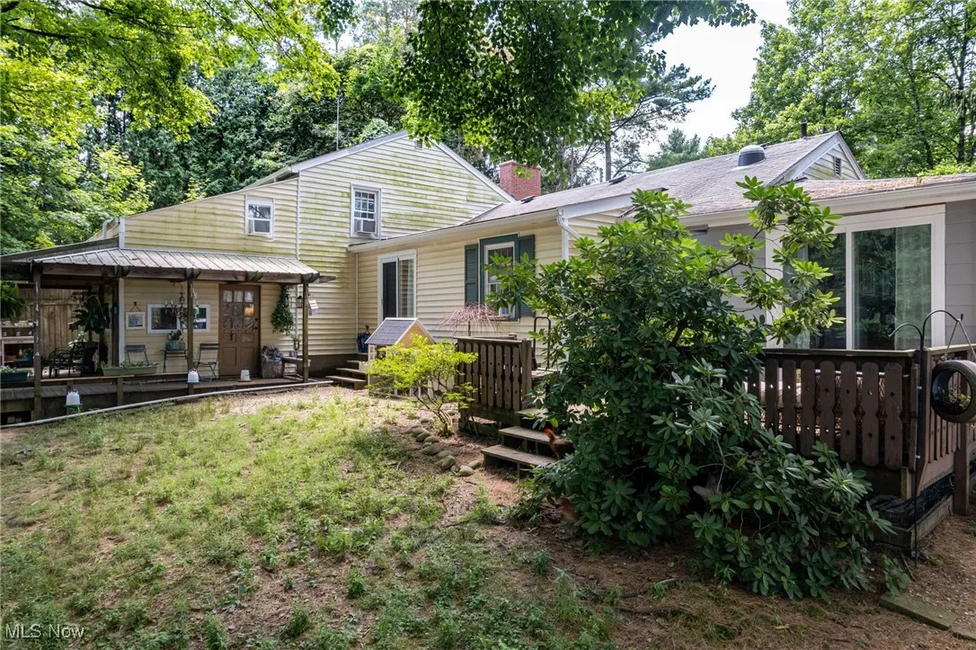 Back of house with a deck and a chimney