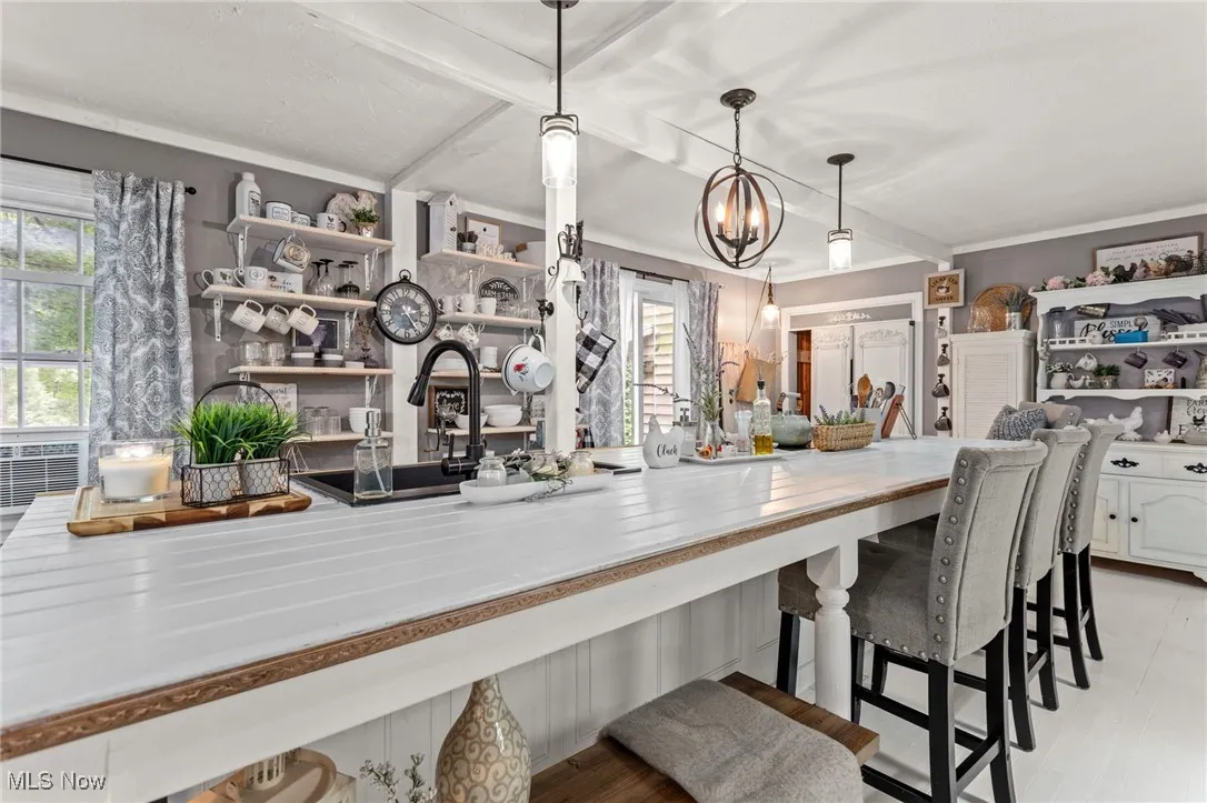 Kitchen featuring open shelves, plenty of natural light, and a chandelier