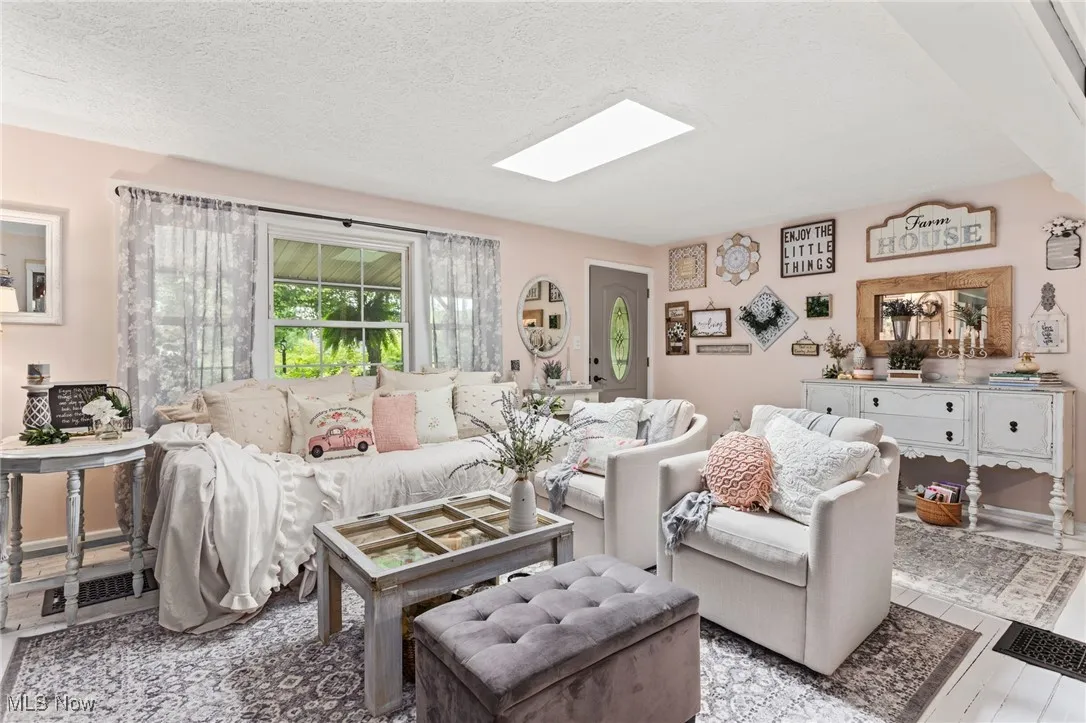 Living area featuring a skylight and a textured ceiling