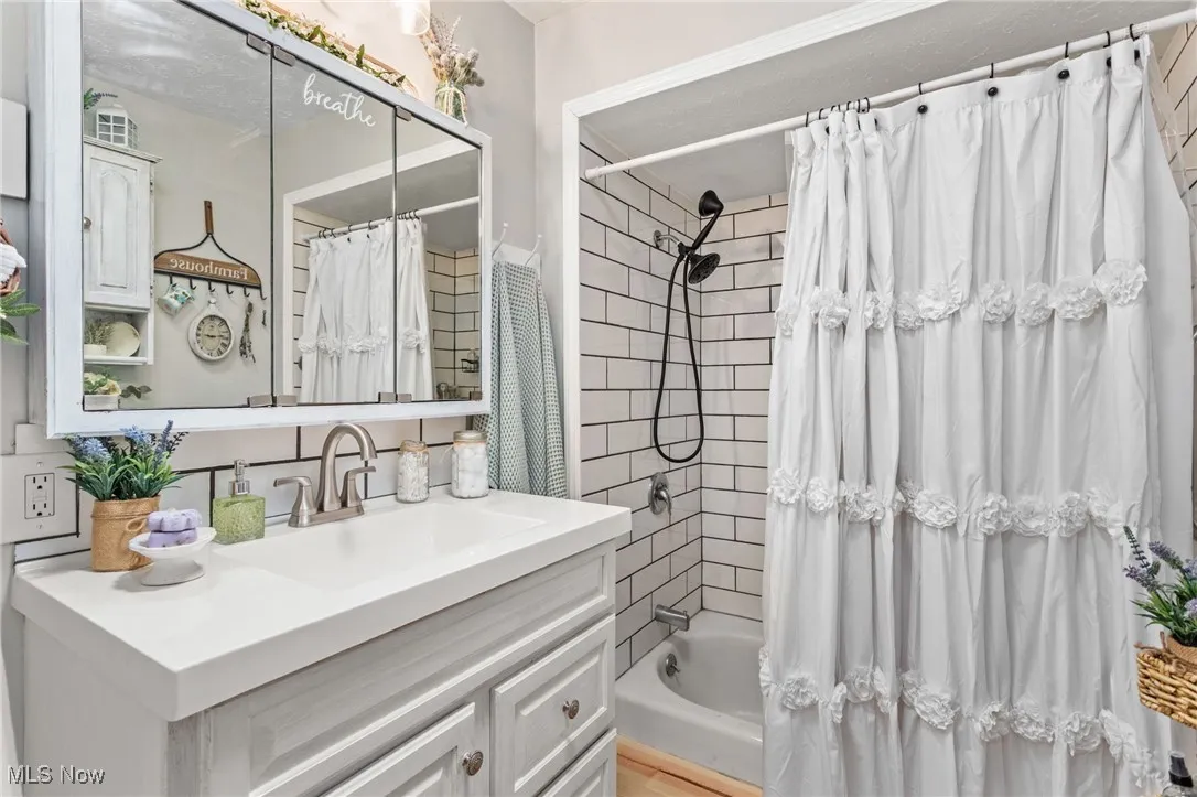 Bathroom featuring vanity and shower / bath combo