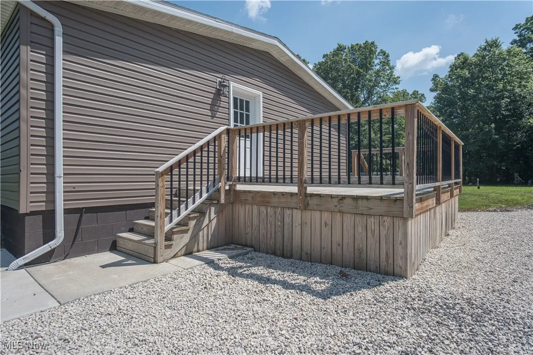 View of side of property featuring a wooden deck