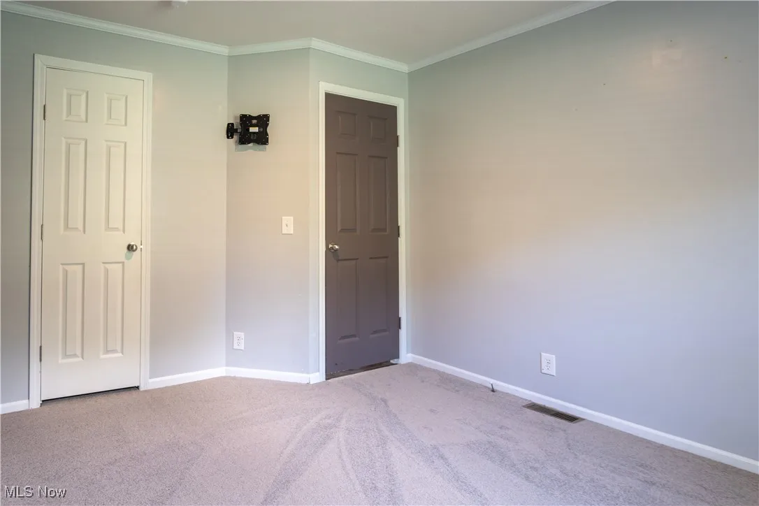 Unfurnished bedroom with carpet and ornamental molding