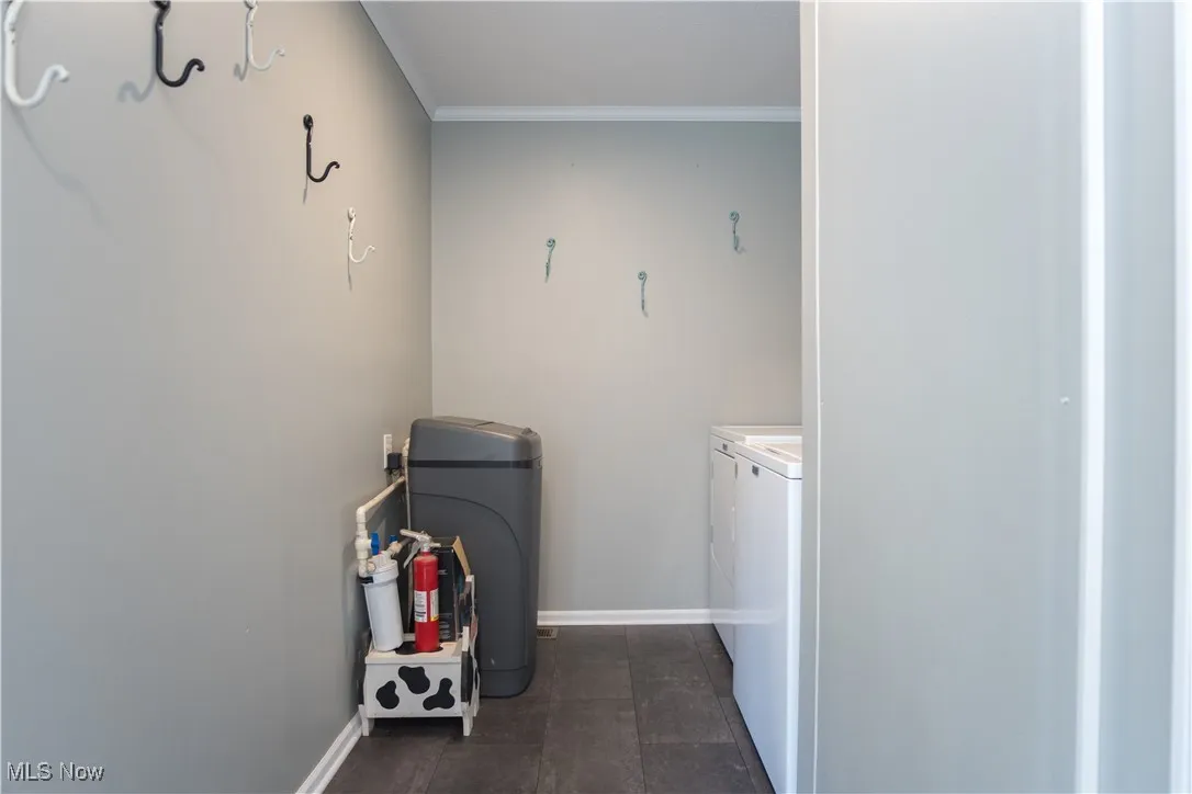 Laundry room featuring washing machine and clothes dryer and crown molding