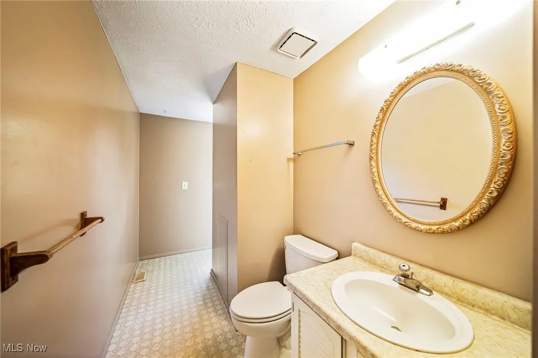 Bathroom with a textured ceiling, vanity, and tile patterned floors