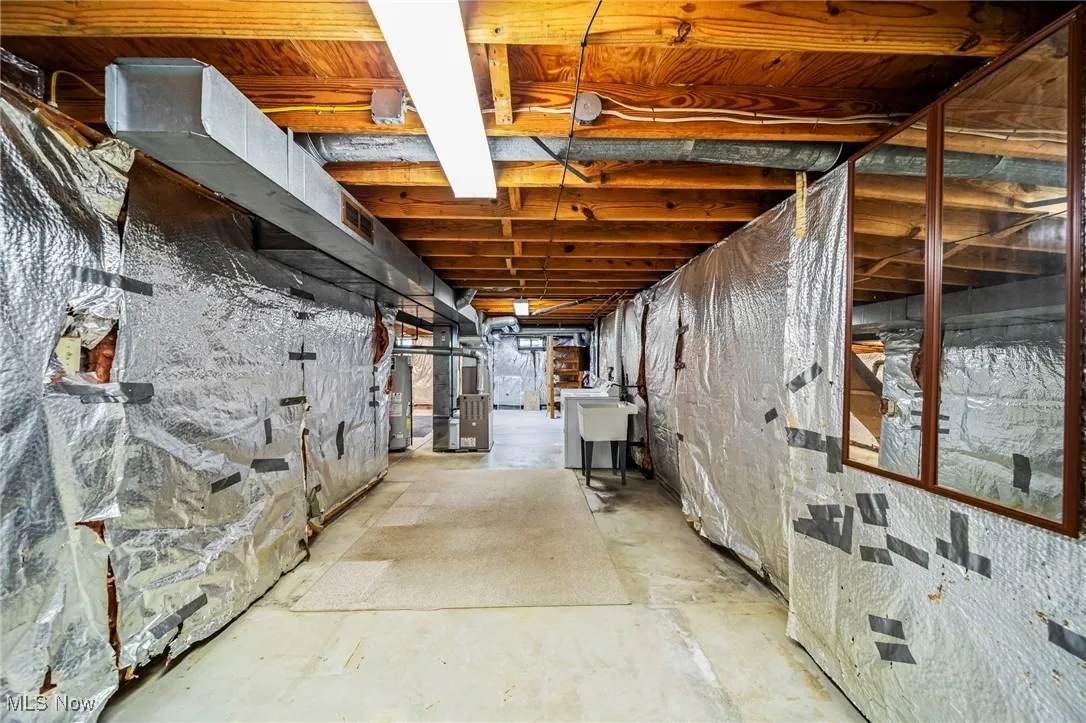 Unfinished below grade area featuring heating unit