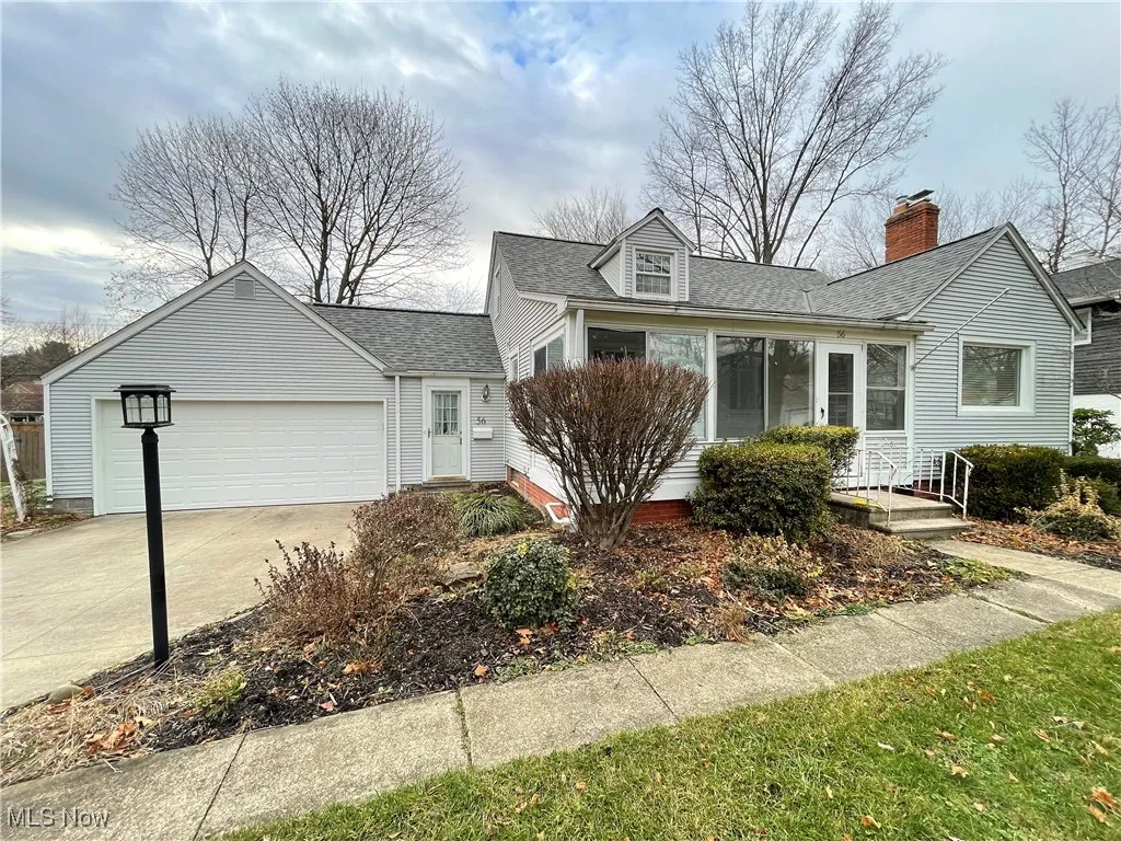 View of front of home with driveway, a shingled roof, a garage, and a​​‌​​​​‌​​‌‌​‌‌​​​‌‌​‌​‌​‌​​​‌​​ chimney