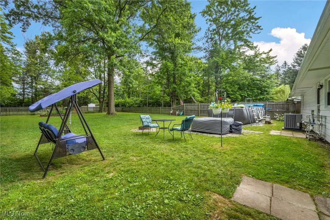 Fenced backyard with view of wooded area