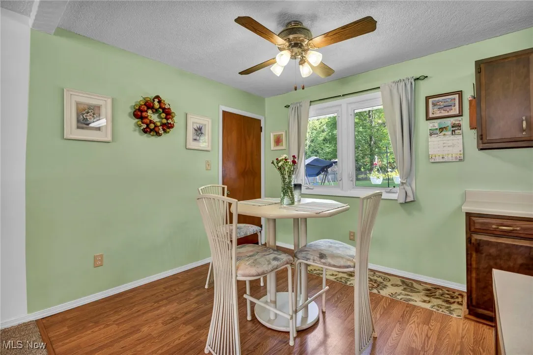 Dining room featuring a textured ceiling, light wood finished floors, and a ceiling fan