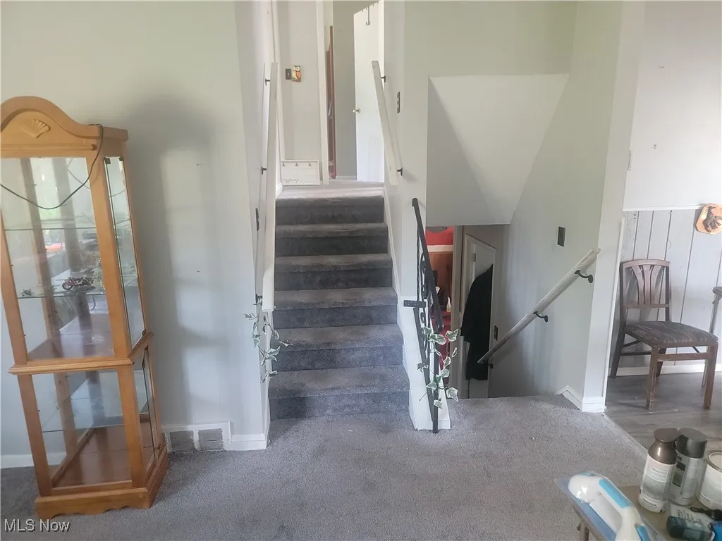 Staircase with carpet flooring and baseboards