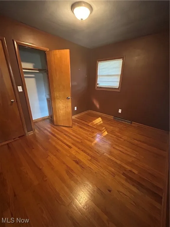 Unfurnished bedroom featuring wood finished floors and a closet