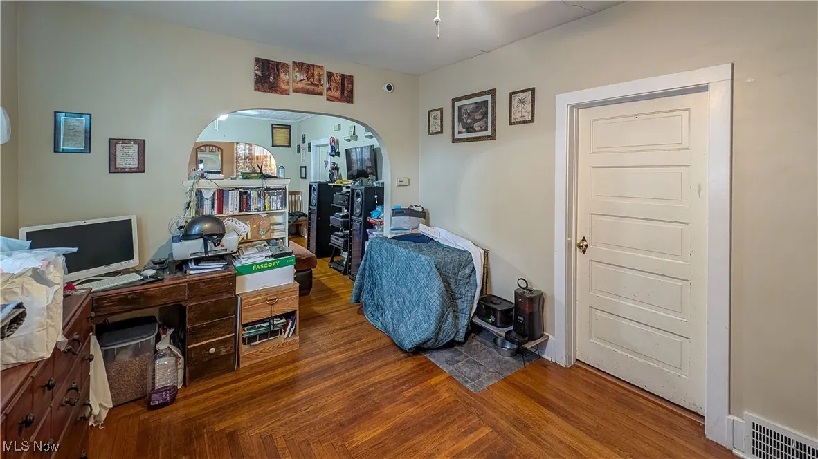 Office featuring arched walkways and wood finished floors