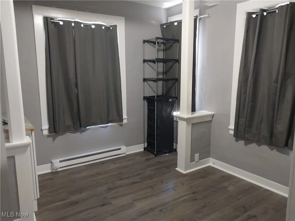 Bathroom featuring baseboard heating and wood finished floors