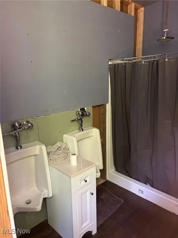 Bathroom with wood finished floors and curtained shower