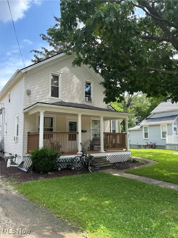 View of front of property with a porch and a front yard