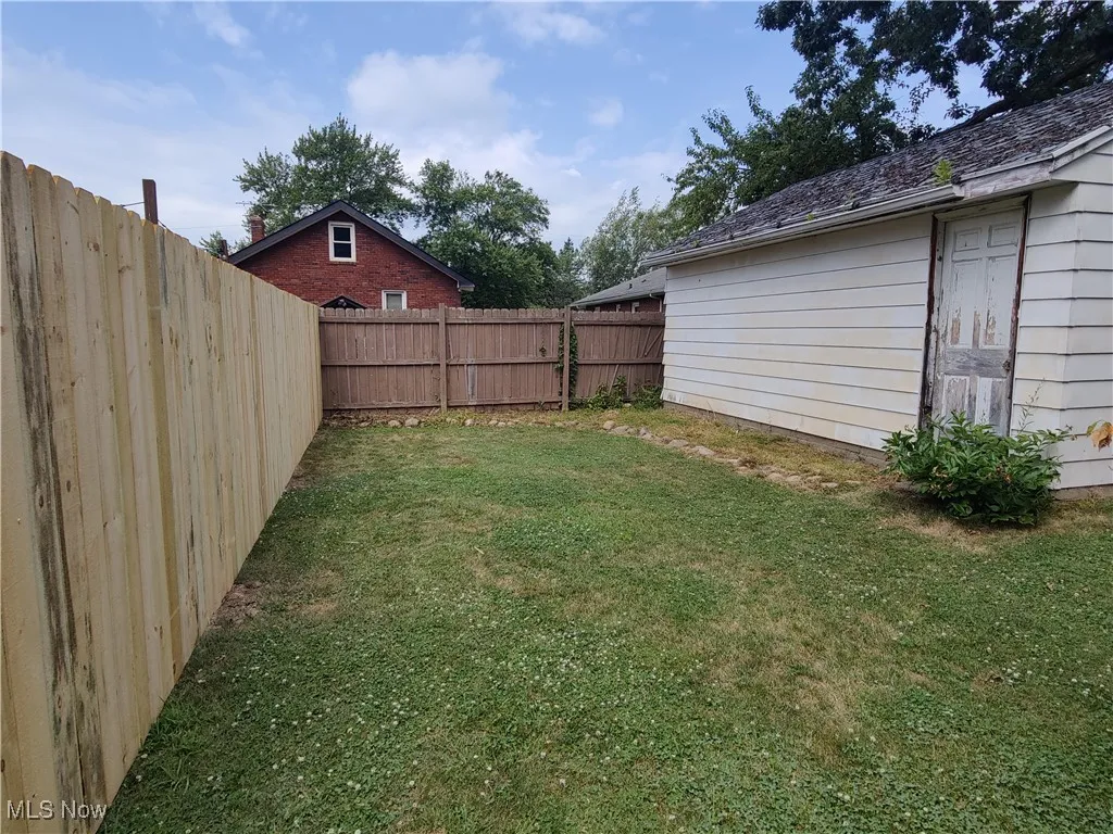 View of fenced backyard and detached garage