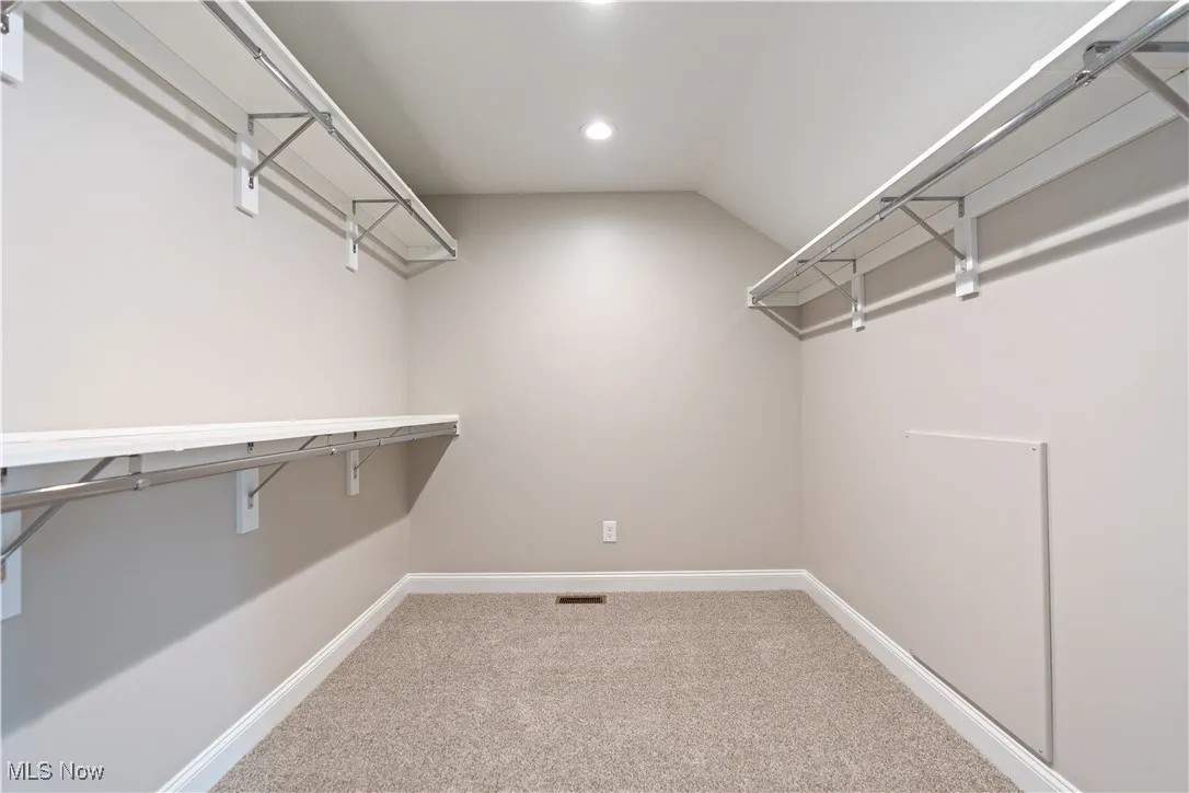Spacious master closet with carpet