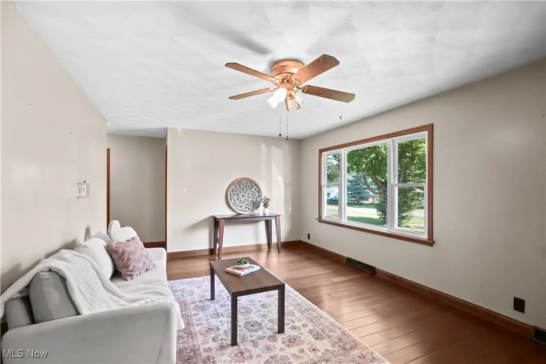 Living area featuring ceiling fan and wood finished floors