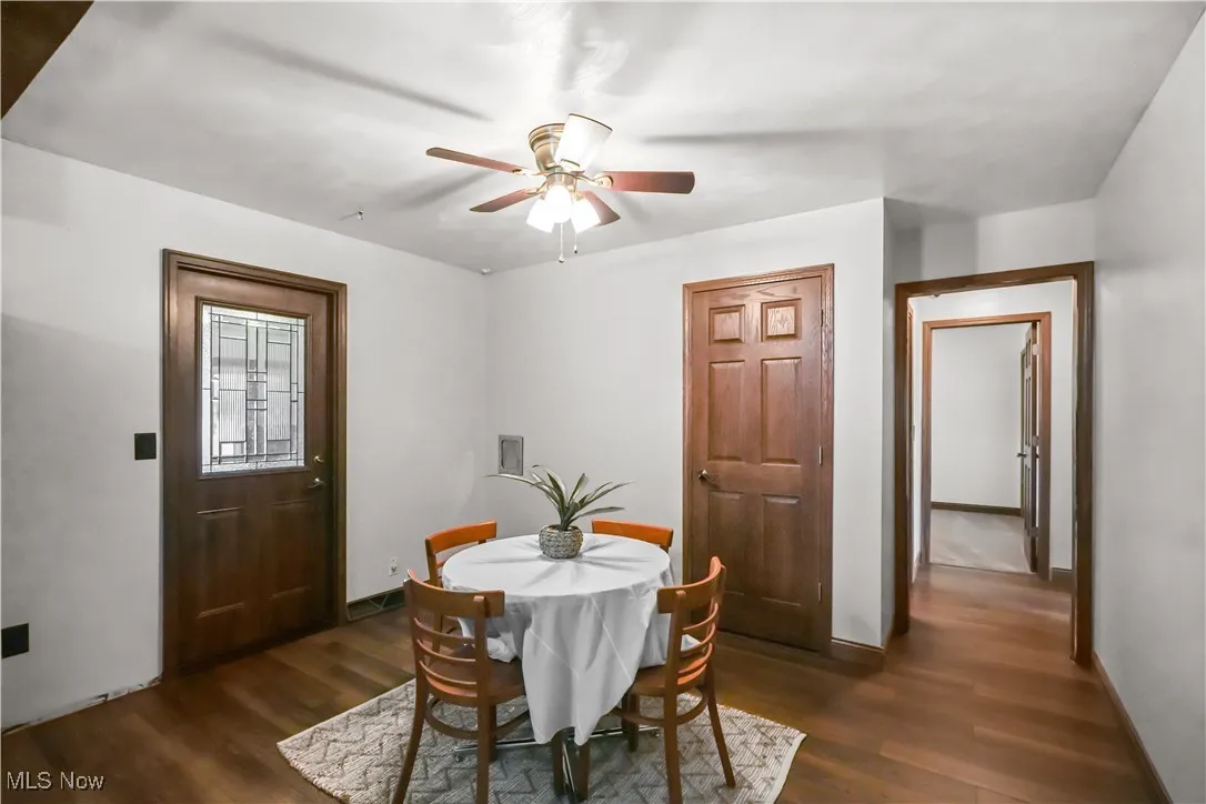 Dining area with dark wood-style floors and a ceiling fan