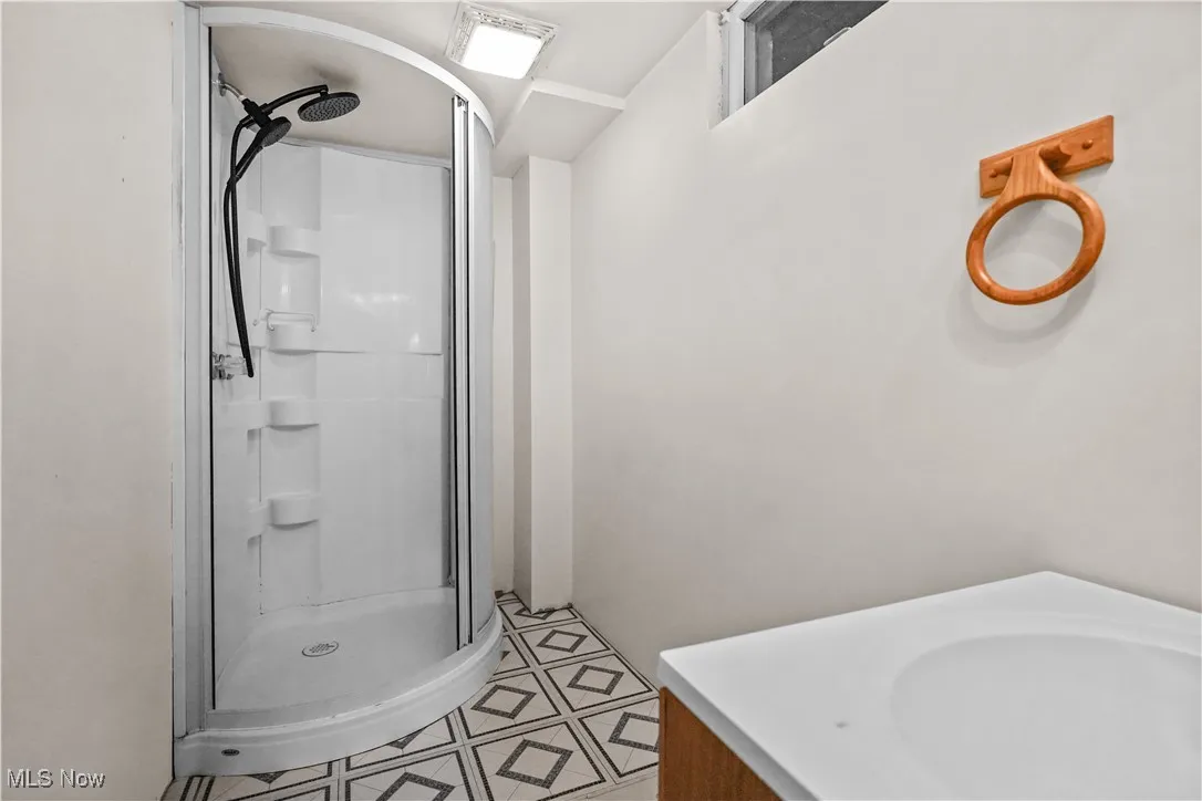 Bathroom with a stall shower, vanity, and tile patterned floors