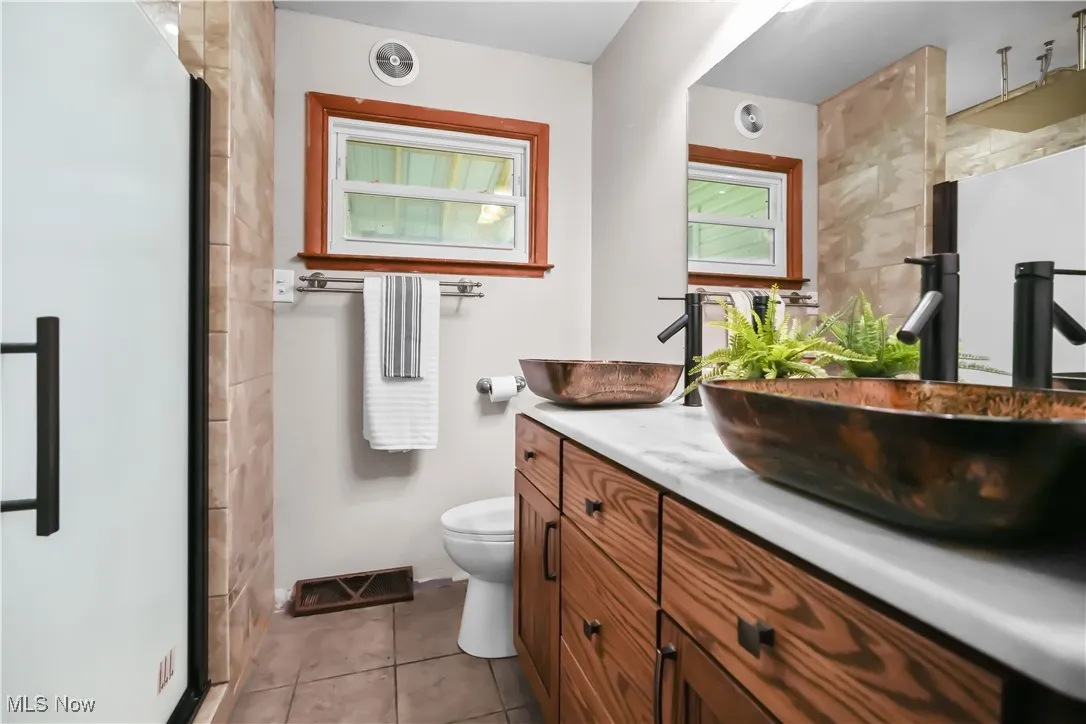 Bathroom with vanity, tile patterned flooring, and a stall shower