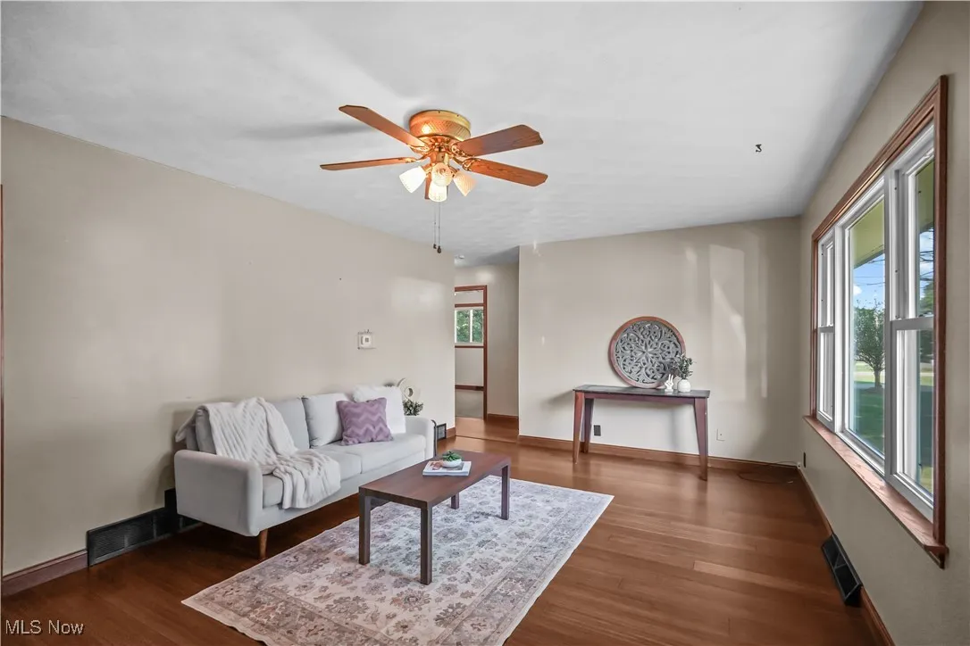 Living area with wood finished floors and a ceiling fan