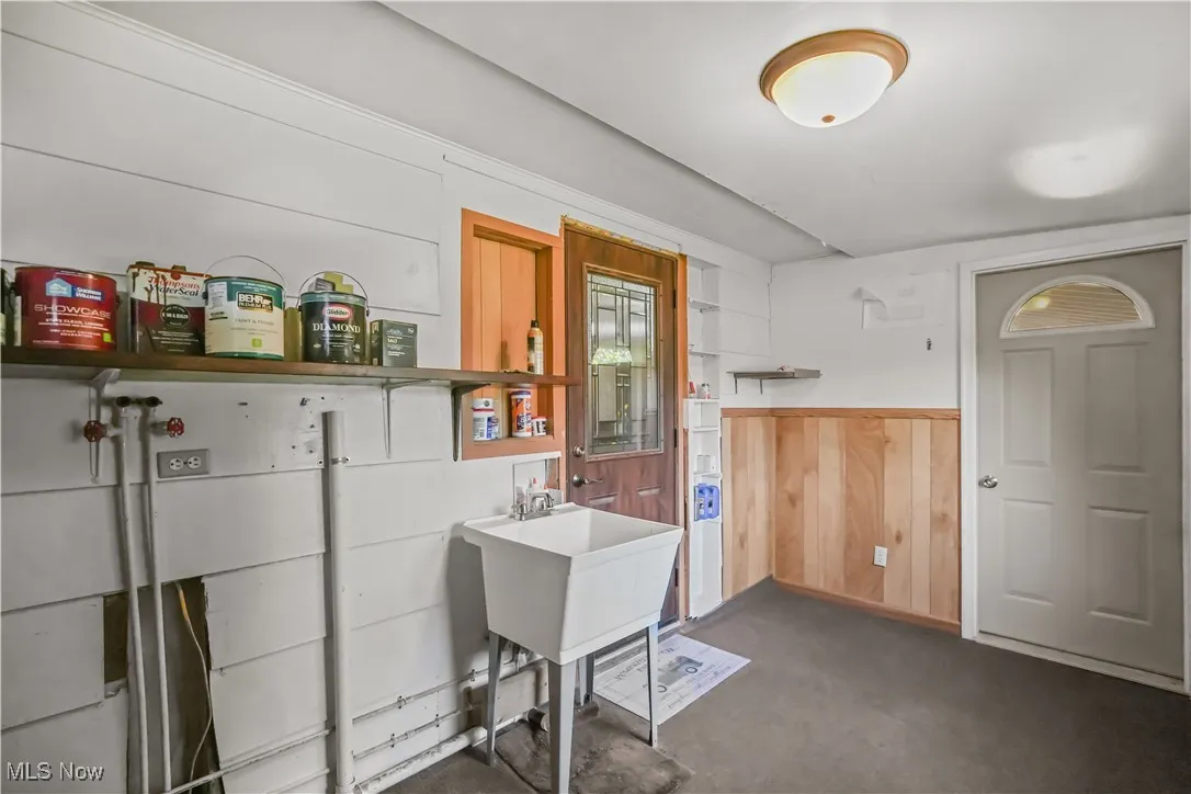 Misc room with dark carpet, wood walls, and wainscoting
