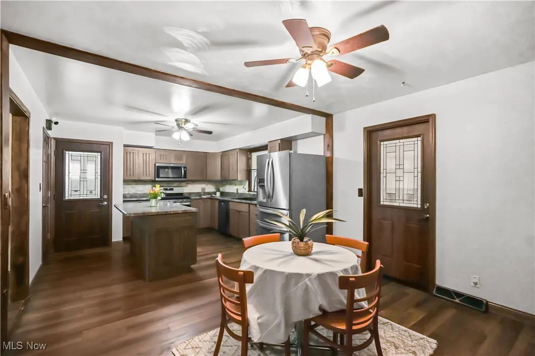 Dining space featuring a ceiling fan and dark wood finished floors
