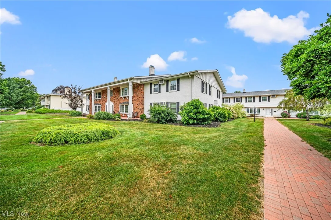 Split foyer home featuring a chimney, a front lawn, and brick siding