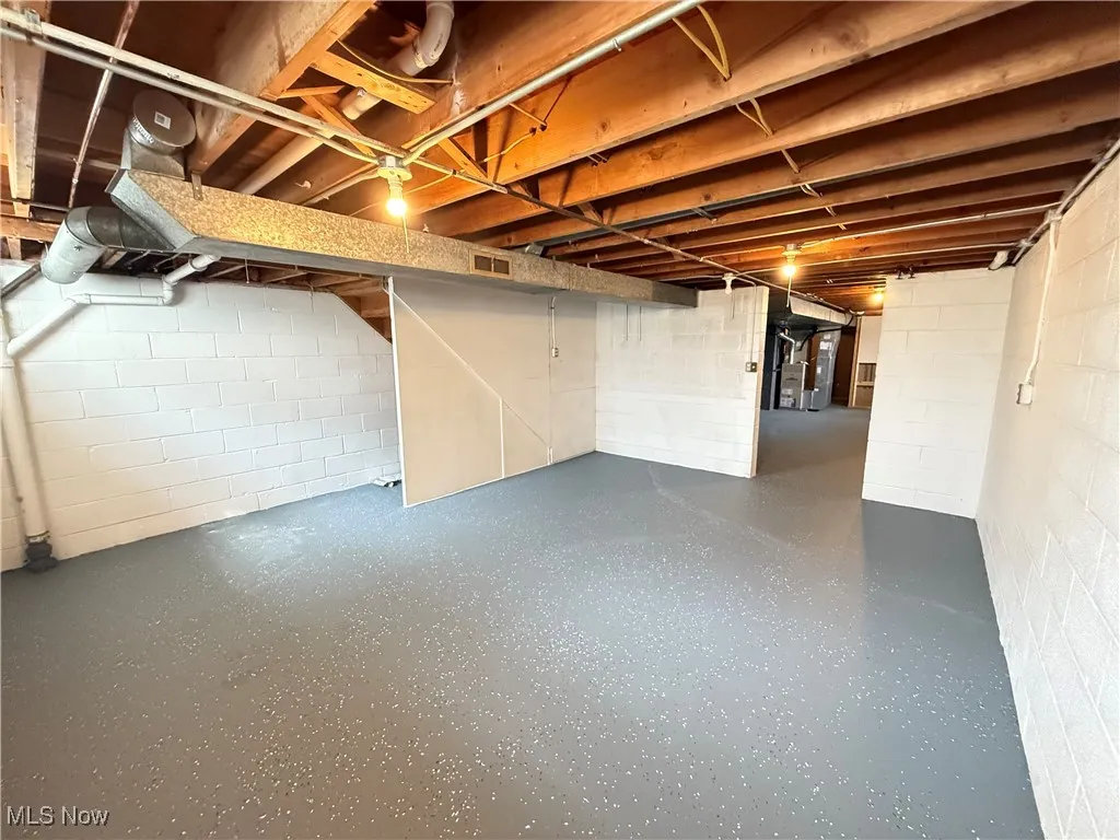 Unfinished basement with concrete block wall