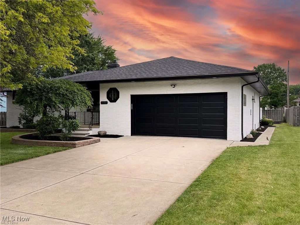 View of front facade featuring brick siding, concrete driveway, a garage, and roof with shingles