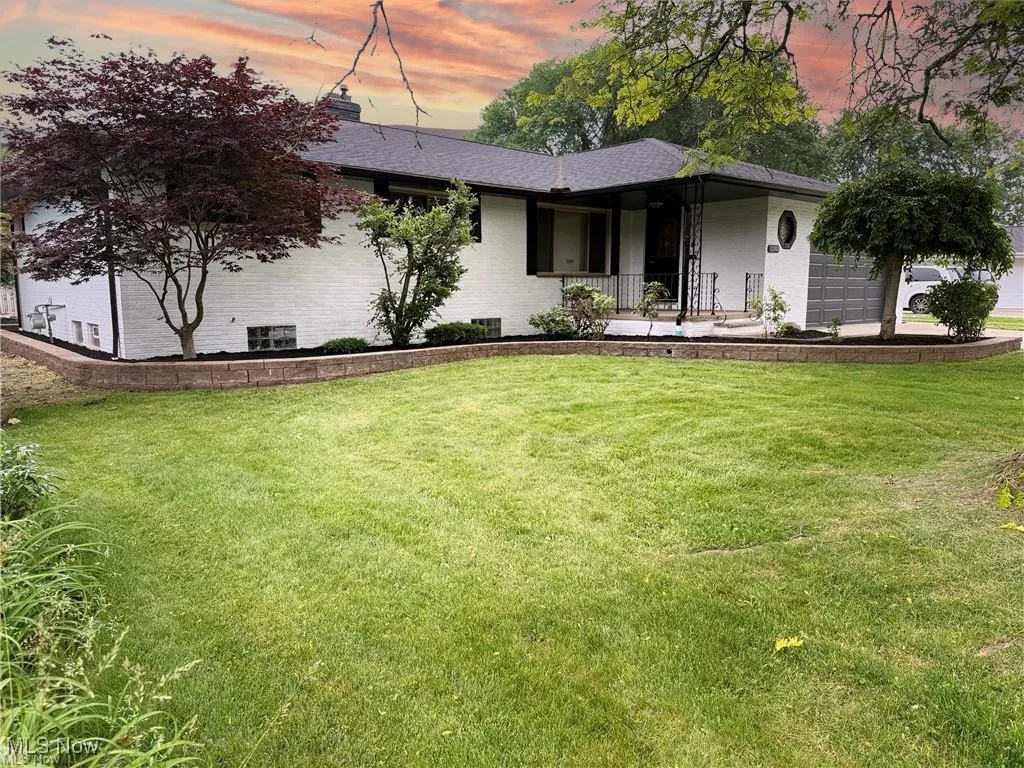 View of front of house featuring a yard and an attached garage