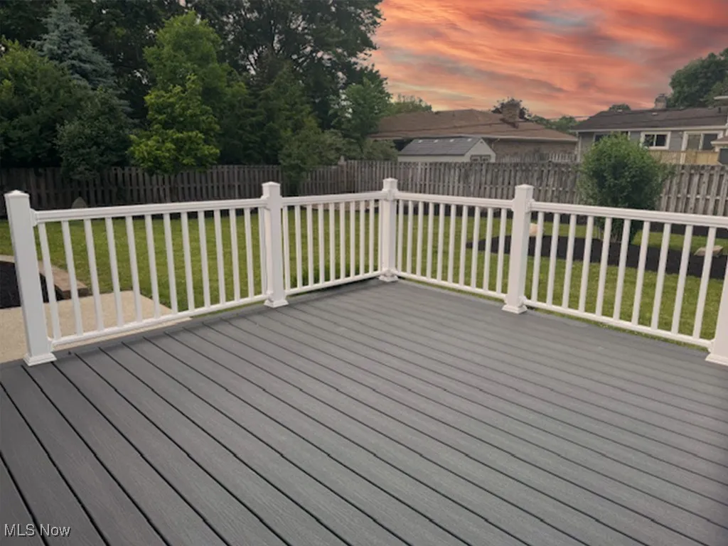 Deck at dusk featuring a fenced backyard