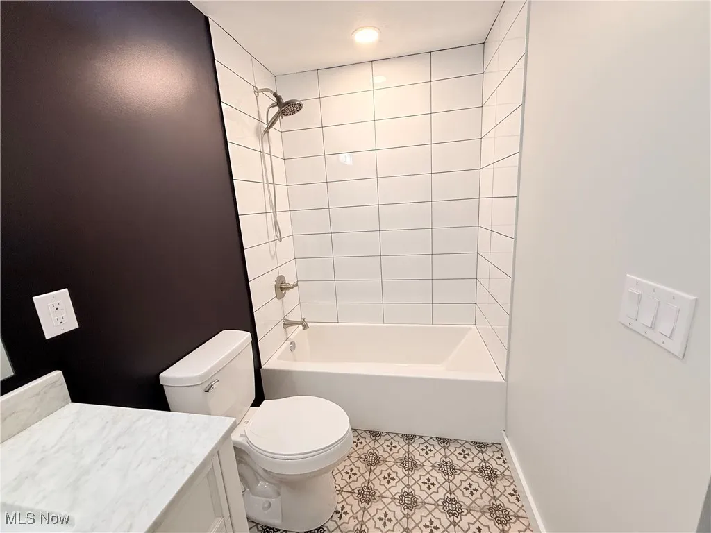 Full bath featuring vanity and washtub / shower combination