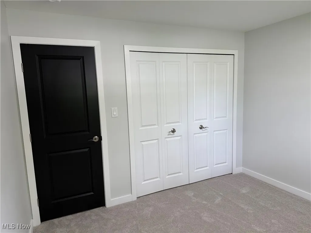Unfurnished bedroom with carpet and a closet