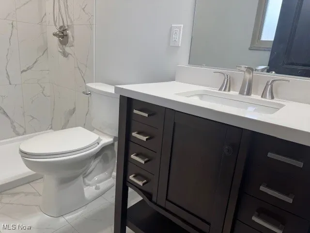 Bathroom with marble finish floors, vanity, and a marble finish shower