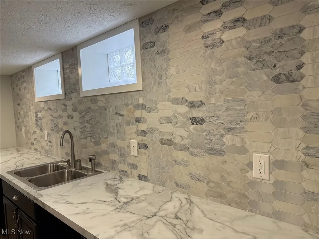 Bathroom featuring a sink and a textured ceiling