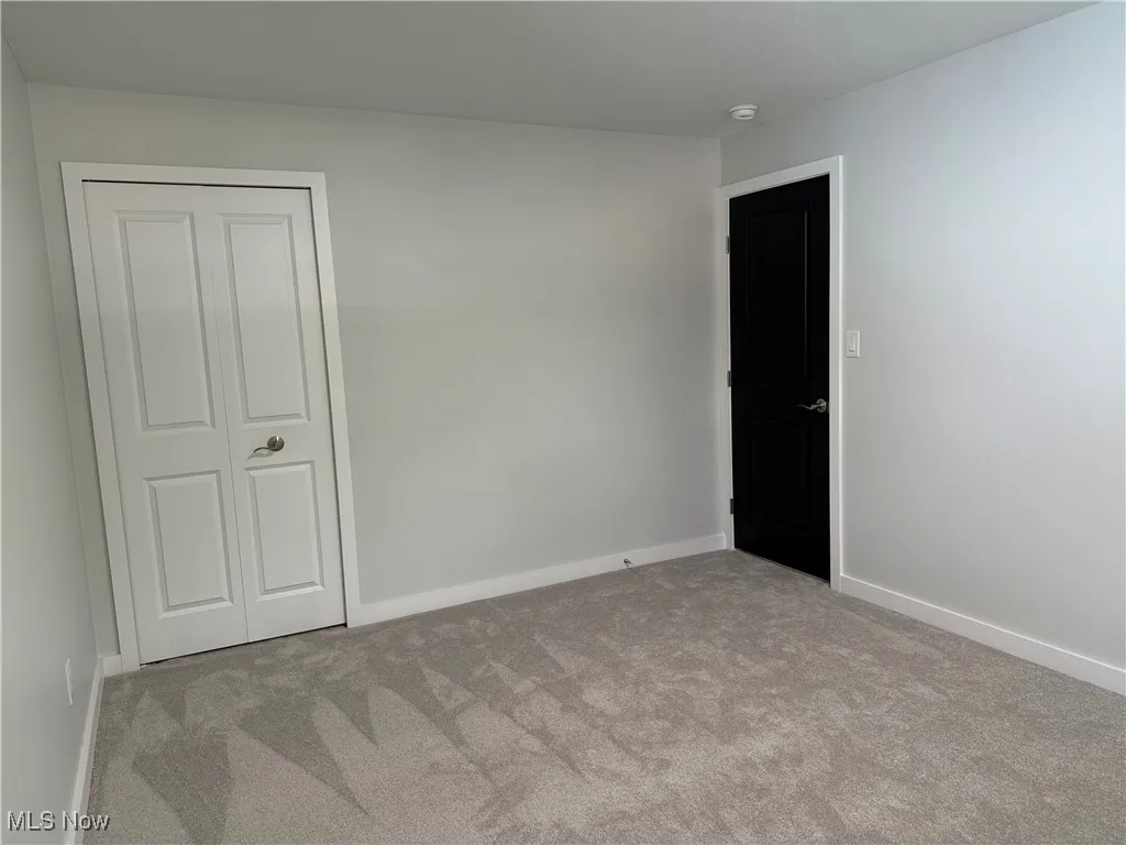 Carpeted empty room with baseboards