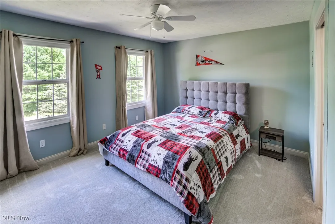 Carpeted bedroom with baseboards and ceiling fan
