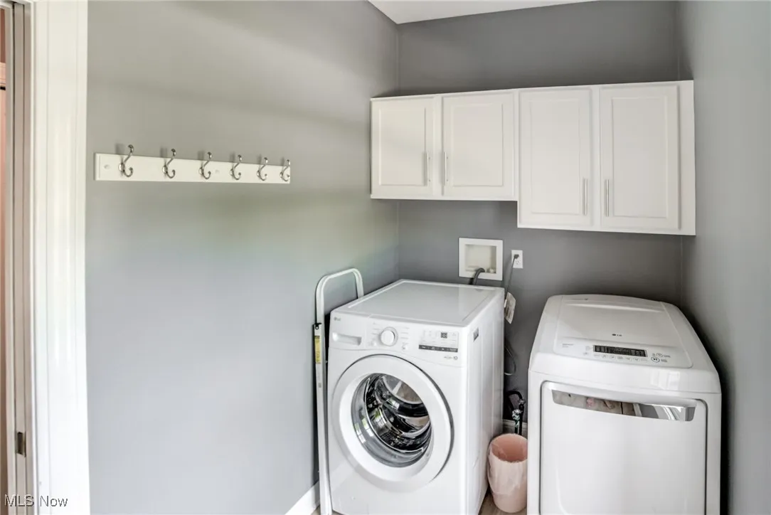 Washroom featuring cabinet space and separate washer and dryer