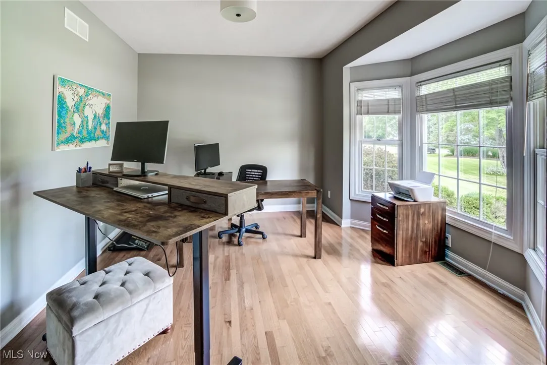 Office space with baseboards and light wood-style floors