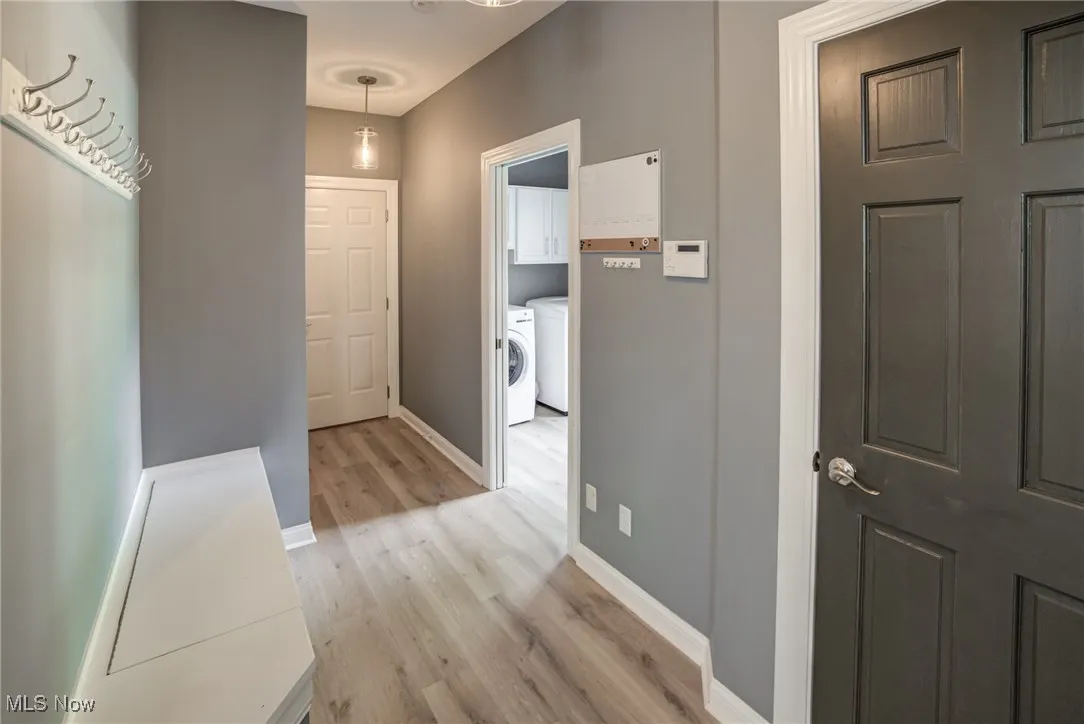 Hallway featuring independent washer and dryer and light wood-type flooring