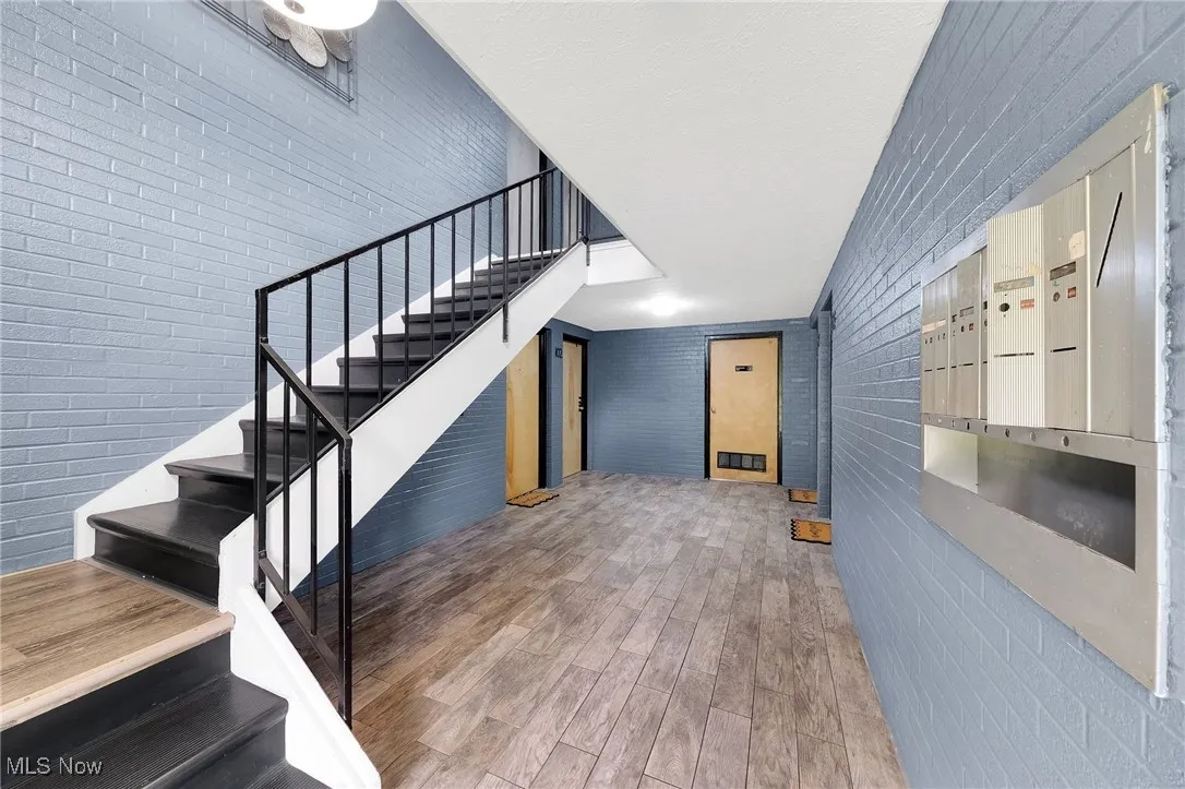 Stairway with brick wall and wood finished floors