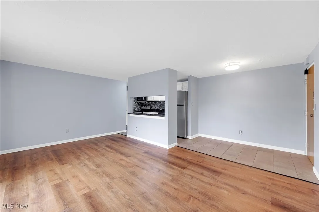 Unfurnished living room with wood finished floors and baseboards