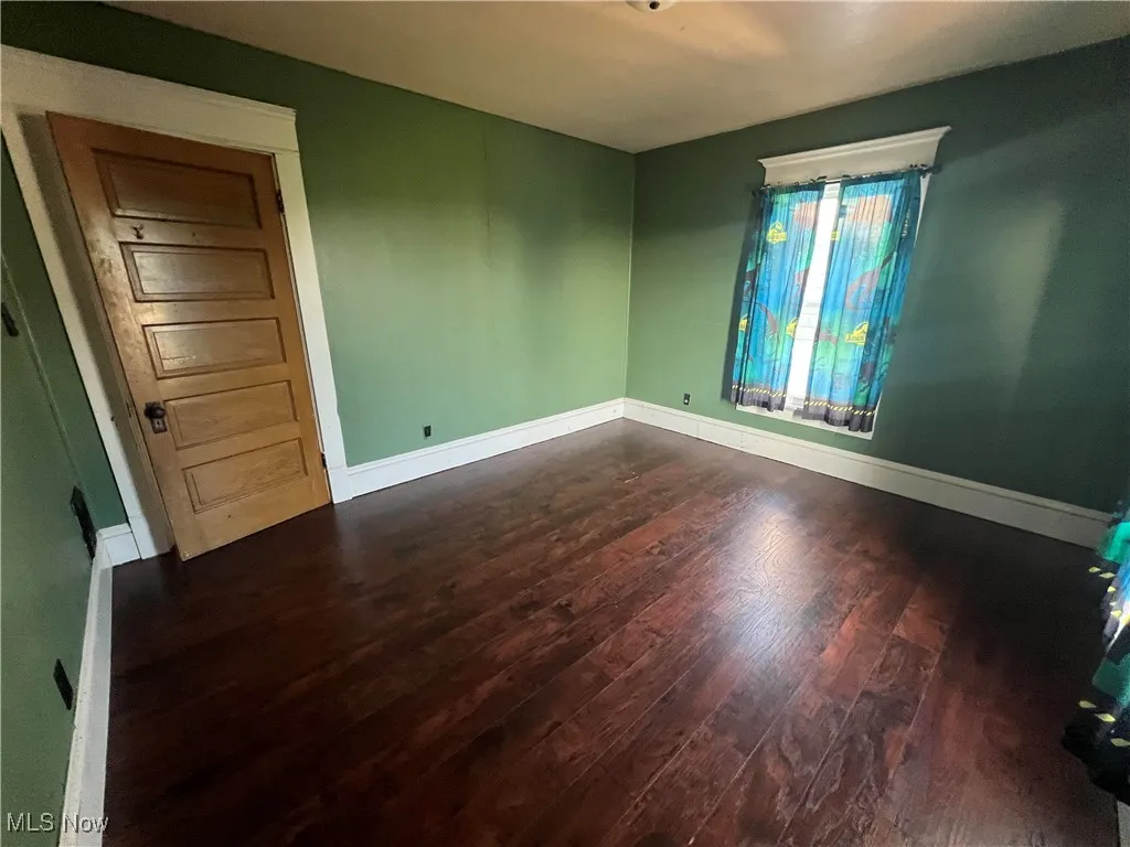 Spare room with dark wood finished floors