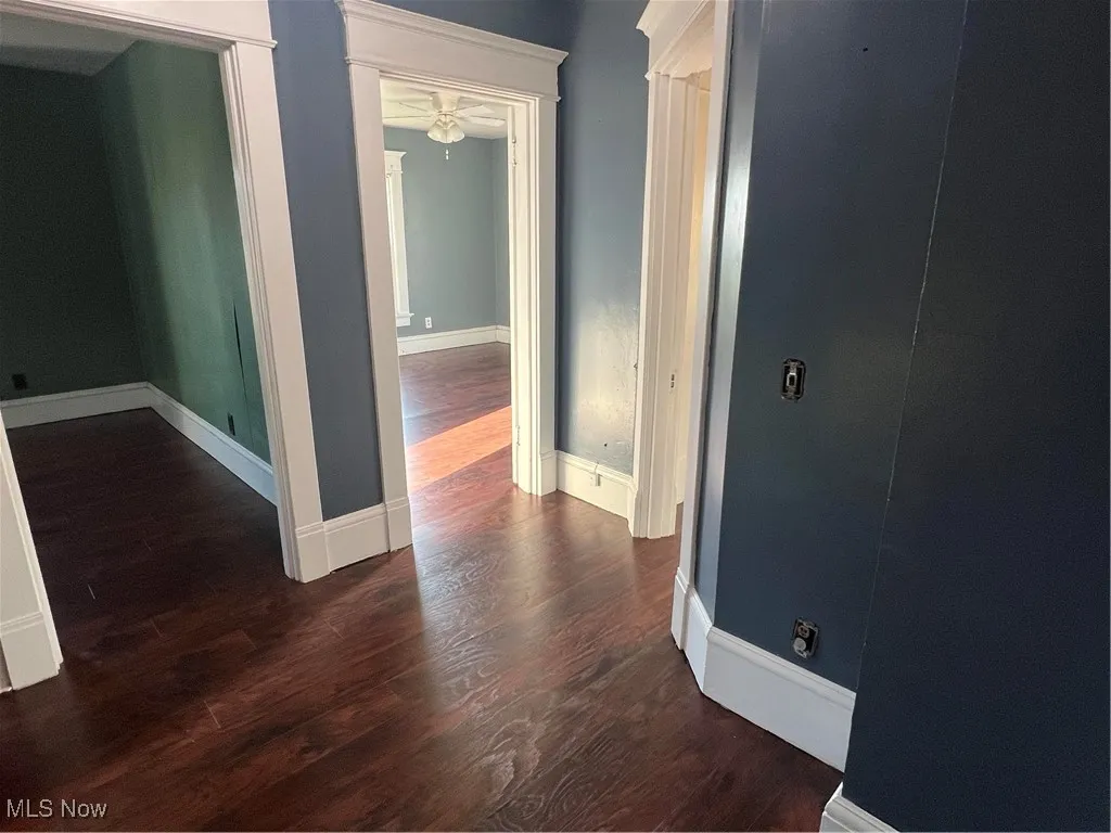 Hallway with wood finished floors and baseboards