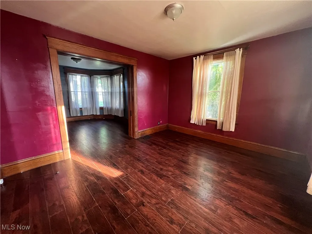 Spare room with baseboards and wood finished floors