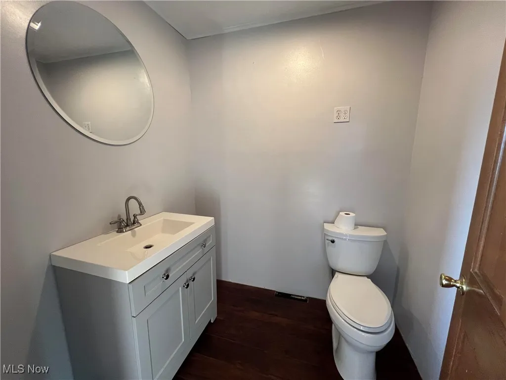 Half bath featuring wood finished floors and vanity