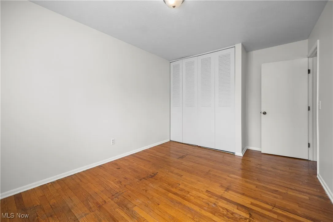 Unfurnished bedroom featuring a closet and hardwood / wood-style flooring